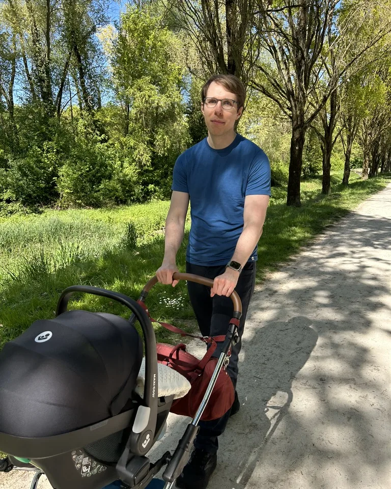 Paul Simmering pushing a pram on a tree-lined path
